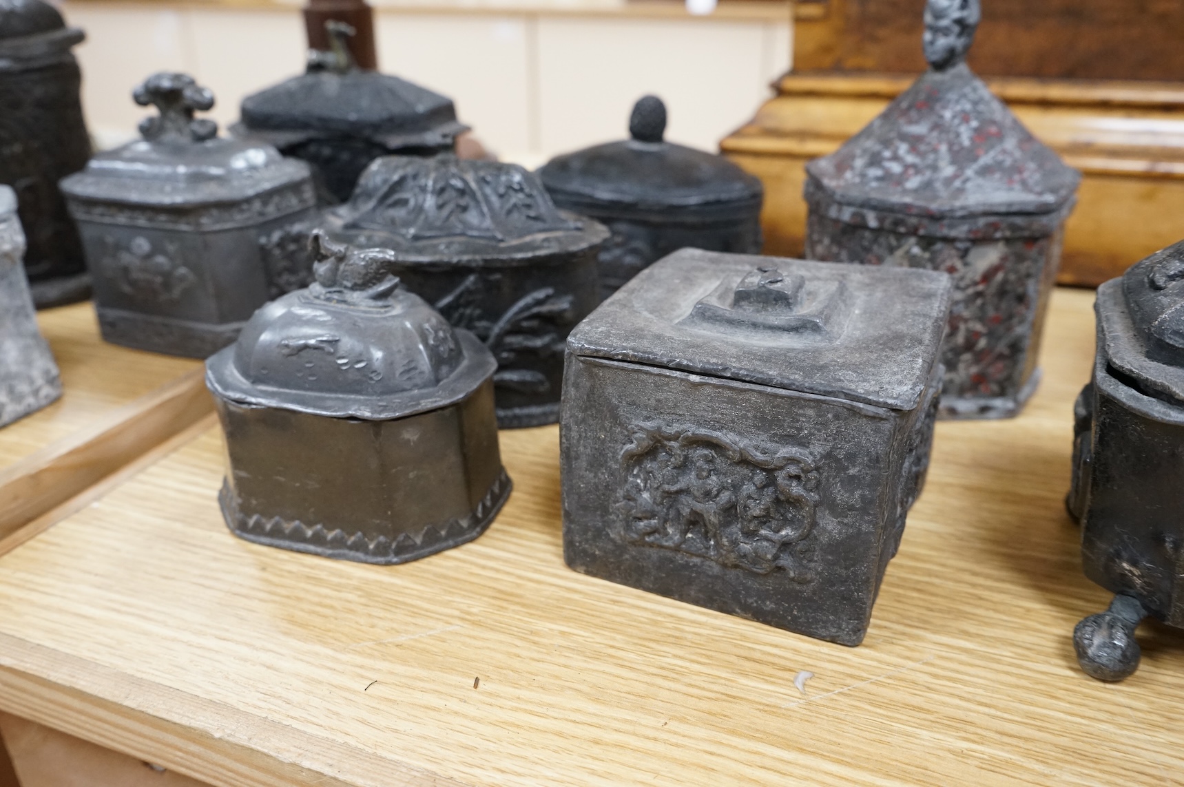 A collection of eleven early 19th century lead tobacco boxes to include an octagonal example with remains of red paint, largest 13cm wide